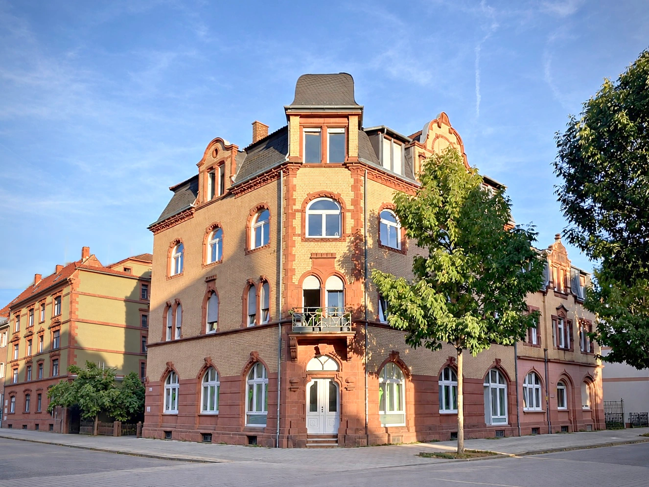 Außenansicht des historischen Praxisgebäudes in Landau; Hintergrund KI-gestützt bearbeitet